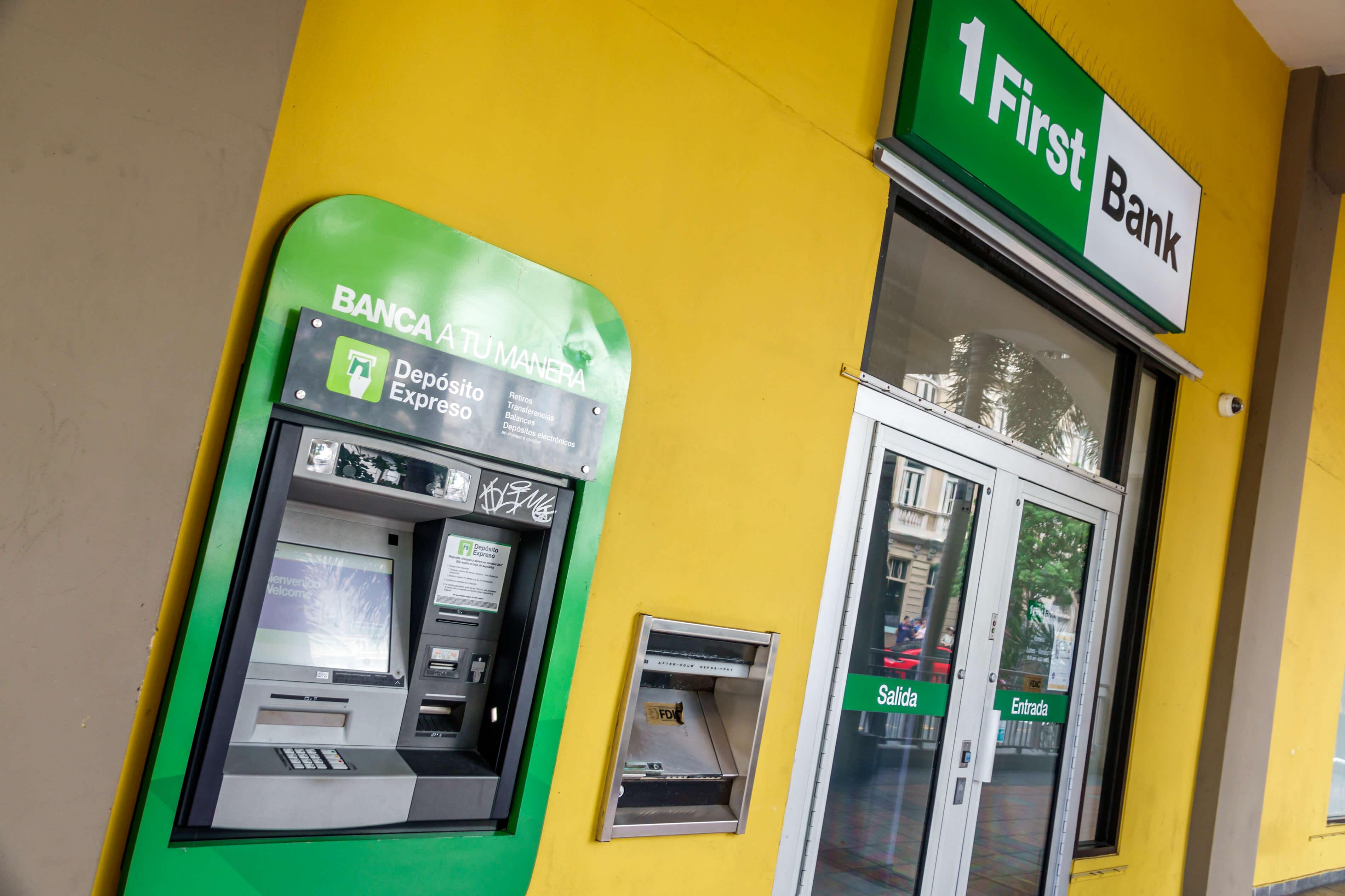 Fachada amarilla de FirstBank con cajero automático verde de depósito expreso y puertas de entrada y salida.
Foto: Jeffrey Greenberg/Universal Images Group via Getty Images
