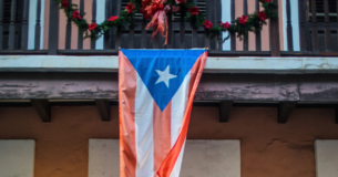Bandera de Puerto Rico colgando de balcón en el Viejo San Juan.