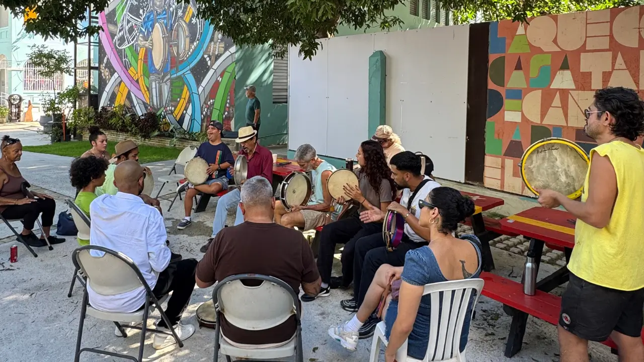 Personas tocando panderos durante un plenazo en la Casa de la Plena Tito Matos